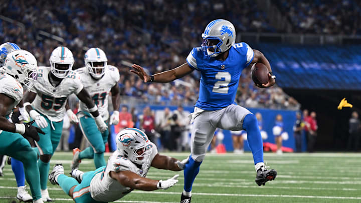 Aug 16, 2025; Detroit, Michigan, USA;  Detroit Lions quarterback Hendon Hooker (2) scrambles away from Miami Dolphins defensive tackle Matt Dickerson (98) to score a touchdown that was nullified by an offensive penalty in the third quarter at Ford Field. Mandatory Credit: Lon Horwedel-Imagn Images