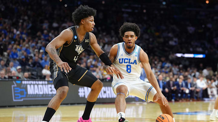 Mar 20, 2026; Philadelphia, PA, USA; UCLA Bruins guard Eric Freeny (8) dribbles the ball against UCF Knights forward Jamichael Stillwell (4) in the first half during a first round game of the men's 2026 NCAA Tournament at Xfinity Mobile Arena. Mandatory Credit: Kyle Ross-Imagn Images