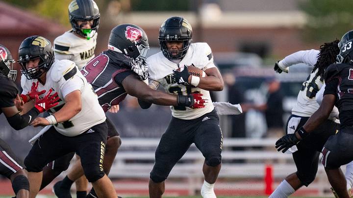 Warren Central High School senior Keyon Thomas (26) works to elude Warren Central High School defenders during the first half of an IHSAA varsity football game, Friday, Sept. 12, 2025, at Lawrence Central High School.