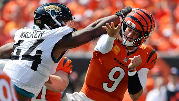 Sep 14, 2025; Cincinnati, Ohio, USA;  Cincinnati Bengals quarterback Joe Burrow (9) takes a hit to the head from Jacksonville Jaguars defensive end Travon Walker (44) during the first quarter at Paycor Stadium. Mandatory Credit: Joseph Maiorana-Imagn Images
