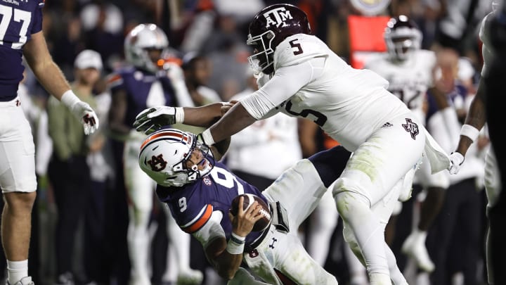 Nov 12, 2022; Auburn, Alabama, USA;  Auburn Tigers quarterback Robby Ashford (9) is shoved to the ground by Texas A&M Aggies defensive lineman Shemar Turner (5) during the second quarter at Jordan-Hare stadium. Turner was flagged for a personal foul, giving Auburn a first down. Mandatory Credit: John Reed-USA TODAY Sports