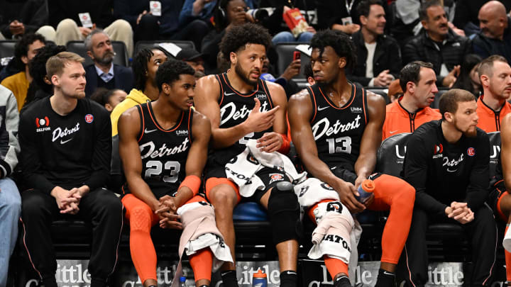 Mar 22, 2024; Detroit, Michigan, USA; Detroit Pistons guard Cade Cunningham (2) (center) talks with guard Jaden Ivey (23) (left) and  center James Wiseman (13) on the bench in the first quarter of their game against the Boston Celtics at Little Caesars Arena. Mandatory Credit: Lon Horwedel-USA TODAY Sports