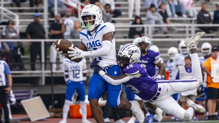 IMG Academy High School junior Donovan Olugbode (1) makes a catch while being defended by Ben Davis High School senior Yassine Falke (13) during the first half of an IHSAA varsity football game, Friday, Sept. 8, 2023, at Ben Davis High School.