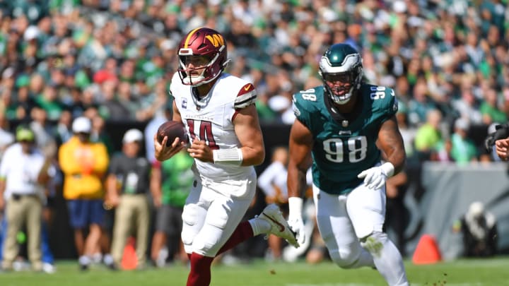 Oct 1, 2023; Philadelphia, Pennsylvania, USA; Washington Commanders quarterback Sam Howell (14) runs past Philadelphia Eagles defensive tackle Jalen Carter (98) during the first quarter at Lincoln Financial Field. 