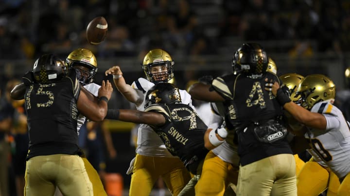 Sophomore quarterback Andrew Indorf, of St. Thomas Aquinas, fires off a pass under pressure from Treasure Coast High School defense during the second quarter at the South County Stadium on Friday, Sept. 23, 2022, in Port St. Lucie. St. Thomas Aquinas won 21-7.