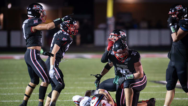 Muskego linebackers Jayden Adams (7), Logan Limberg (33) and Brody Axelson (45) and defensive lineman Caleb Hein (30) celebrate a sack of Arrowhead quarterback Nolan Hanson (3) in a game Friday, September 19, 2025, at Muskego High School in Muskego, Wisconsin.