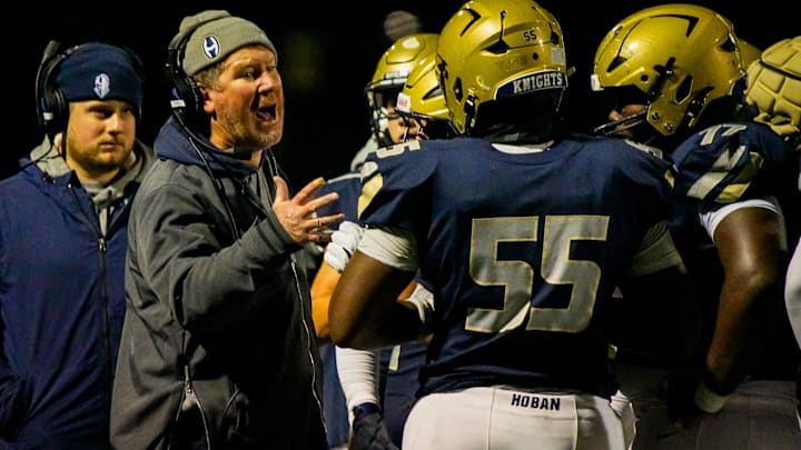 Archbishop Hoban football coach Tim Tyrrell talks to his team during last week's rivalry game against St. Edward.