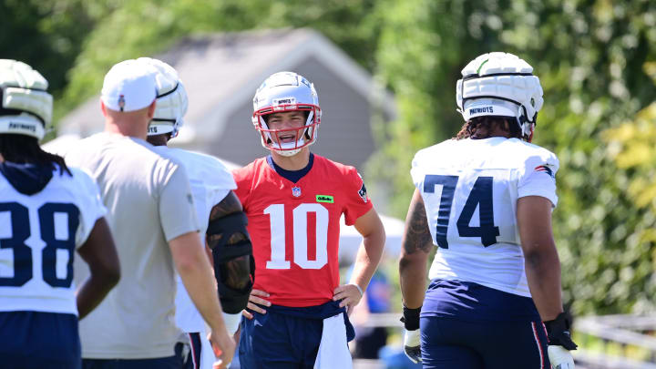 Jul 26, 2024; Foxborough, MA, USA; New England Patriots quarterback Drake Maye (10) talks to coaching staff members between snaps during training camp at Gillette Stadium. Mandatory Credit: Eric Canha-USA TODAY Sports