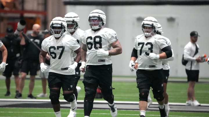 Jul 31, 2023; Henderson, NV, USA; Las Vegas Raiders offensive tackle Justin Murray (67), center Andre James (68) and  guard Vitaliy Gurman (73) wear Guardian helmet caps during training camp at the Intermountain Health Performance Center. Mandatory Credit: Kirby Lee-USA TODAY Sports