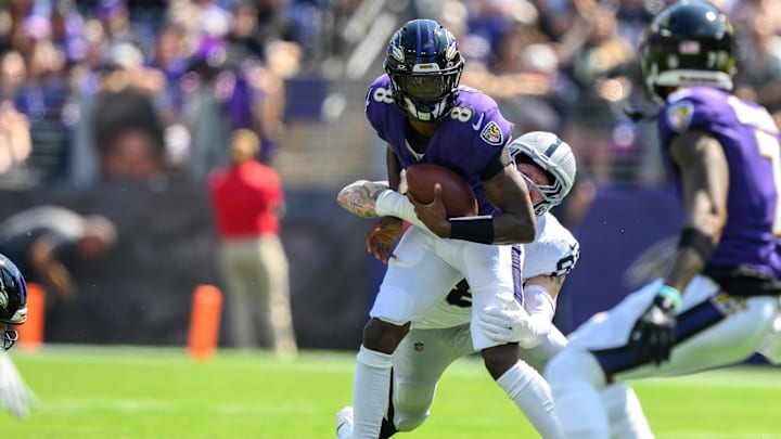 Sep 15, 2024; Baltimore, Maryland, USA; Baltimore Ravens quarterback Lamar Jackson (8) is sacked by Las Vegas Raiders defensive end Maxx Crosby (98) during the first half at M&T Bank Stadium. Mandatory Credit: Reggie Hildred-Imagn Images