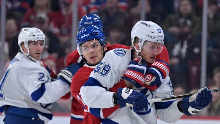 Apr 9, 2026; Montreal, Quebec, CAN; Montreal Canadiens forward Jake Evans (71) grabs Tampa Bay Lightning forward Jake Guentzel (59) during the first period at the Bell Centre. Mandatory Credit: Eric Bolte-Imagn Images
