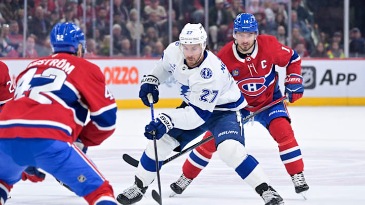 Apr 9, 2026; Montreal, Quebec, CAN; Tampa Bay Lightning defenseman Ryan McDonagh (27) plays the puck and Montreal Canadiens defenseman Adam Engstrom (42) defends with teammate forward Nick Suzuki (14) during the first period at the Bell Centre. Mandatory Credit: Eric Bolte-Imagn Images