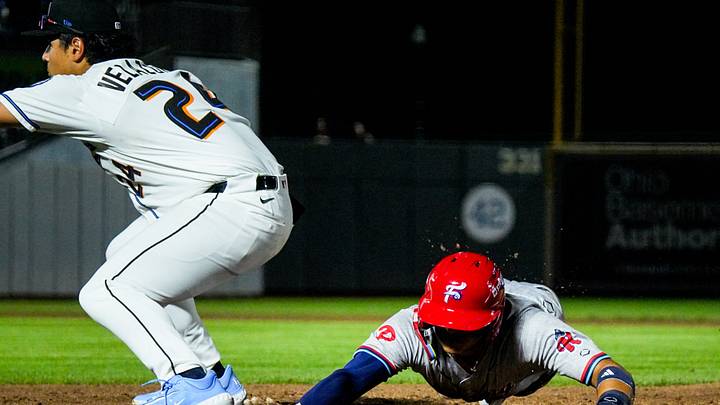 Reading infielder Bryan Rincon (4) dives back into first base during the home opening day game against Akron, April 2, 2026, in Akron, Ohio.