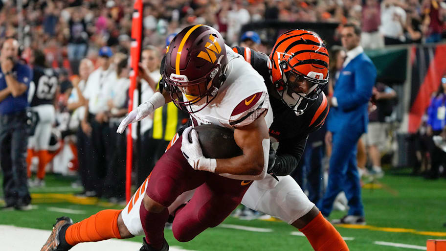 Washington Commanders running back Austin Ekeler is tackled by Cincinnati Bengals safety Geno Stone. | Cara Owsley/The Enquirer / USA TODAY NETWORK via Imagn Images