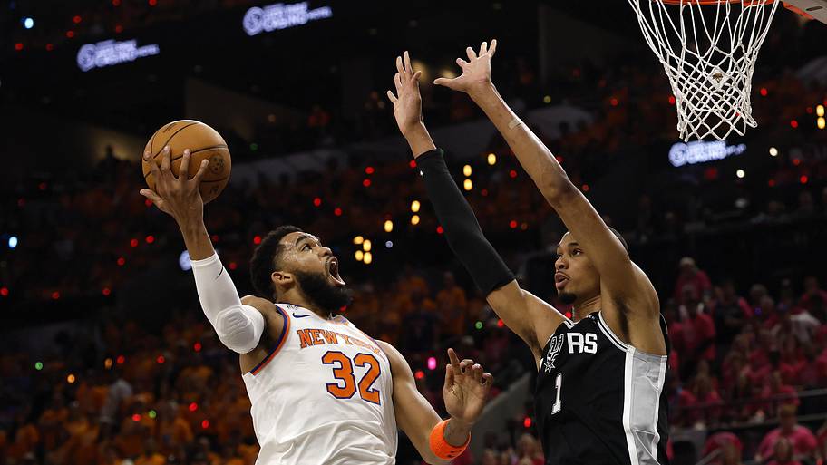 New York Knicks center Karl-Anthony Towns shoots the ball past San Antonio Spurs forward Victor Wembanyama.