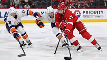 Nov 21, 2024; Detroit, Michigan, USA; Detroit Red Wings center Dylan Larkin (71) tries to skate past New York Islanders defenseman Noah Dobson (8) and defenseman Alexander Romanov (28) in the second period at Little Caesars Arena. Mandatory Credit: Lon Horwedel-Imagn Images