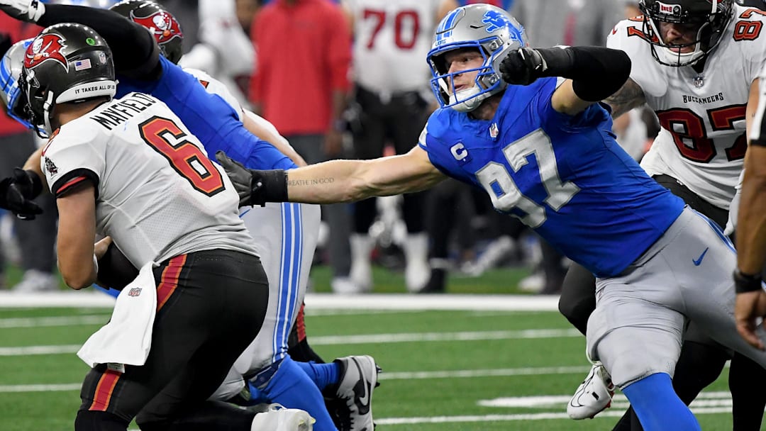 Sep 15, 2024; Detroit, Michigan, USA; Detroit Lions defensive end Aidan Hutchinson (97) attempts to tackle Tampa Bay Buccaneers quarterback Baker Mayfield (6) in the fourth quarter at Ford Field. Mandatory Credit: Eamon Horwedel-Imagn Images