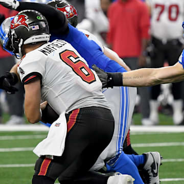 Sep 15, 2024; Detroit, Michigan, USA; Detroit Lions defensive end Aidan Hutchinson (97) attempts to tackle Tampa Bay Buccaneers quarterback Baker Mayfield (6) in the fourth quarter at Ford Field. Mandatory Credit: Eamon Horwedel-Imagn Images