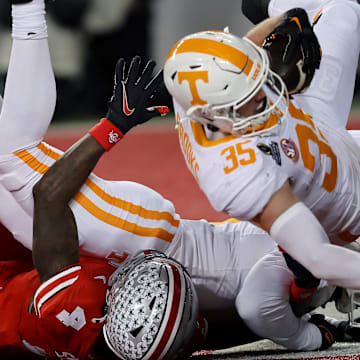 Dec 21, 2024; Columbus, Ohio, USA;  Ohio State Buckeyes wide receiver Jeremiah Smith (4) has a ball deflected to Tennessee Volunteers defensive back Will Brooks (35) who completes the interception during the second quarter at Ohio Stadium. Mandatory Credit: Joseph Maiorana-Imagn Images