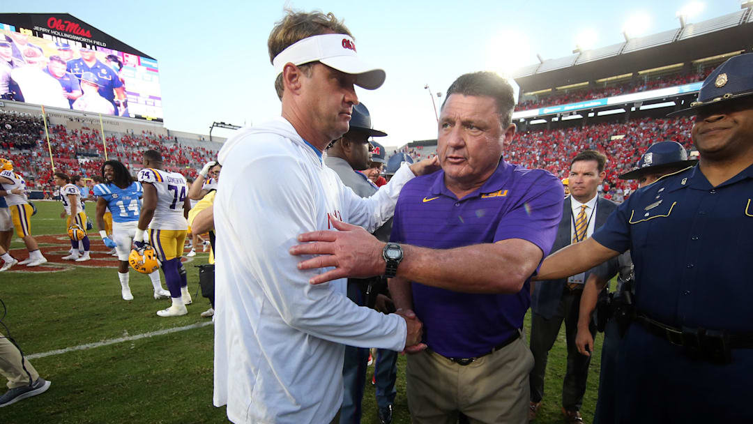 Oct 23, 2021; Oxford, Mississippi, USA; Mississippi Rebels head coach Lane Kiffin (left) and LSU Tigers head coach Ed Orgeron (right) shake hands after a game at Vaught-Hemingway Stadium. Mandatory Credit: Petre Thomas-Imagn Images Oct 23, 2021; Oxford, Mississippi, USA; Mississippi Rebels head coach Lane Kiffin (left) and LSU Tigers head coach Ed Orgeron (right) shake hands after a game at Vaught-Hemingway Stadium. Mandatory Credit: Petre Thomas-Imagn Images