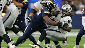 Nov 30, 2025; Inglewood, California, USA; Los Angeles Chargers defensive tackle Justin Eboigbe (92) tackles Las Vegas Raiders running back Ashton Jeanty (2) during the second half at SoFi Stadium. 