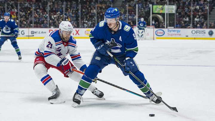 New York Rangers  forward Barclay Goodrow checks Vancouver Canucks forward J.T. Miller.