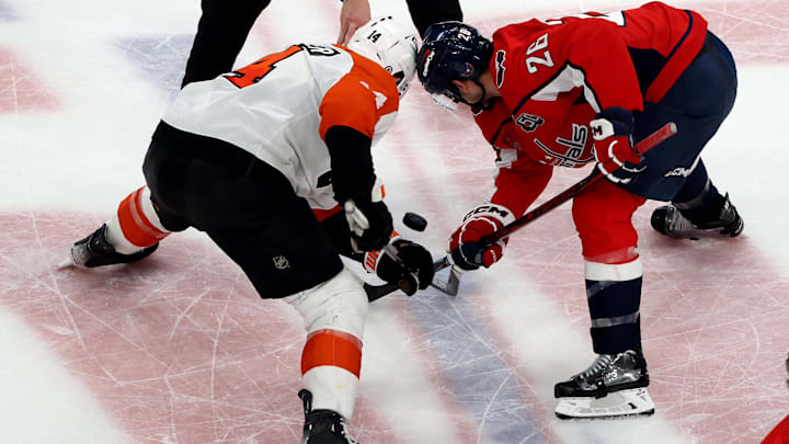 Mar 20, 2025; Washington, District of Columbia, USA; Philadelphia Flyers center Sean Couturier (14) and Washington Capitals center Nic Dowd (26) face off during the third period at Capital One Arena. 