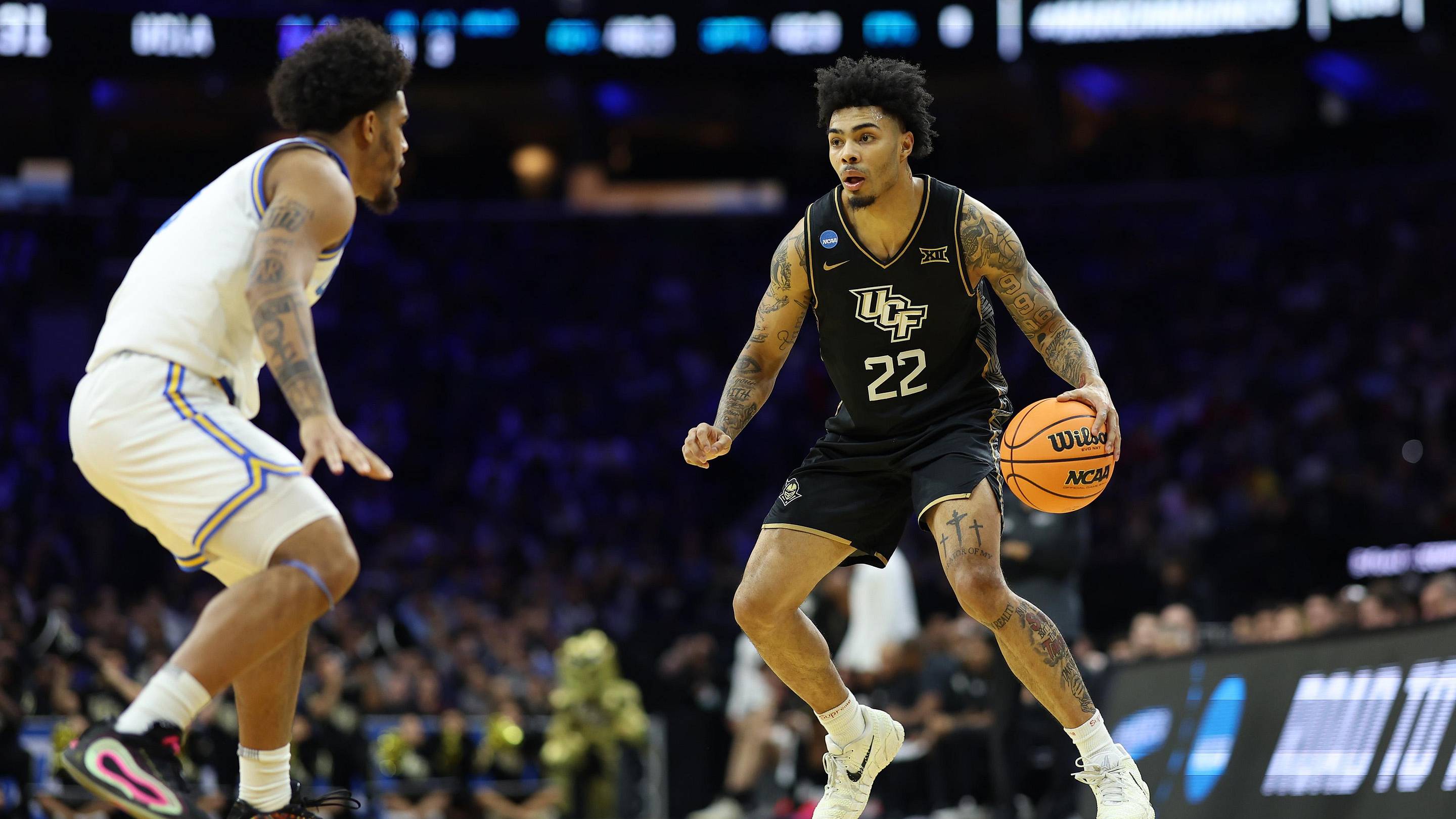 Mar 20, 2026; Philadelphia, PA, USA; UCF Knights guard Chris Johnson (22) dribbles the ball against the UCLA Bruins in the first half during a first round game of the men's 2026 NCAA Tournament at Xfinity Mobile Arena. Mandatory Credit: Bill Streicher-Imagn Images | Bill Streicher-Imagn Images