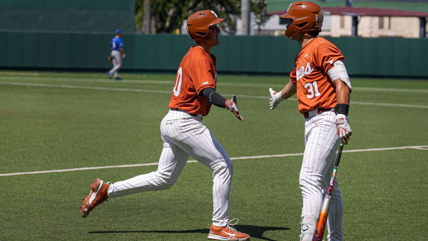 Texas Longhorns catcher Kimble Schuessler (10) celebrates a sccore with infielder Casey Borba (31).