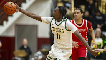 Indianapolis Crispus Attucks High School senior Dezmon Briscoe (11) reaches for the ball during the first half of an IHSAA Class 3A Semi-State semi-final basketball game against Princeton High School, Saturday, March 22, 2025, at Southport High School.