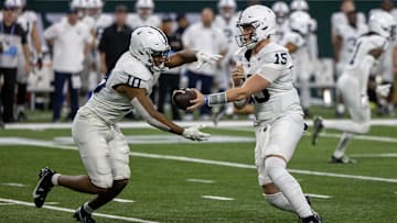 Penn State football quarterback Drew Allar hands off the ball to running back Nicholas Singleton