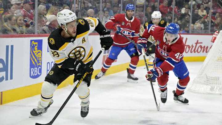Apr 3, 2025; Montreal, Quebec, CAN; Boston Bruins forward David Pastrnak (88) plays the puck and Montreal Canadiens defenseman Lane Hutson (48) defends during the first period at the Bell Centre. Mandatory Credit: Eric Bolte-Imagn Images