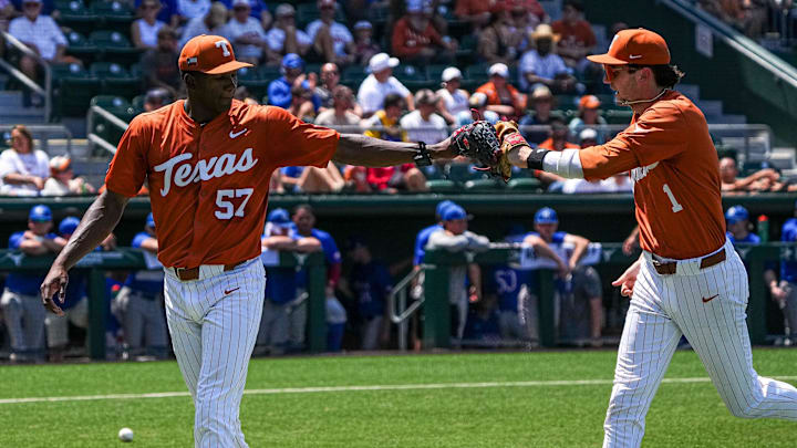 Texas Longhorns pitcher Lebarron Johnson Jr. (57) bumps gloves with infielder Jalin Flores (1) after a catch for a third out during the game against Kansas at UFCU Disch–Falk Field on Saturday, May. 18, 2024 in Austin.