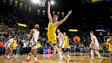 Mar 2, 2025; Ann Arbor, Michigan, USA;  Michigan Wolverines center Danny Wolf (1) loses control of the ball while driving to the basket against Illinois Fighting Illini guard Kylan Boswell (4) in the first half at Crisler Center. Mandatory Credit: Lon Horwedel-Imagn Images