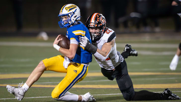 Grafton defensive lineman Max Glab (22) brings down Catholic Memorial quarterback Dalton Steinke (2) in a WIAA Division 3 state semifinal Friday, November 14, 2025. Grafton defensive lineman Max Glab (22) brings down Catholic Memorial quarterback Dalton Steinke (2) in a WIAA Division 3 state semifinal Friday, November 14, 2025.