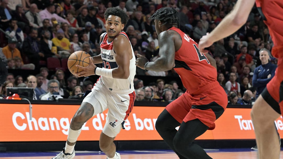 Oct 6, 2024; Montreal, Quebec, CAN; Washington Wizards shooting guard Jordan Poole (13) /p/ and Toronto Raptors point guard Davion Mitchell (45) defends during the first quarter at the Bell Centre. Mandatory Credit: Eric Bolte-Imagn Images