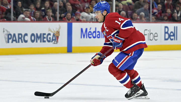 Jan 6, 2025; Montreal, Quebec, CAN; Montreal Canadiens forward Nick Suzuki (14) plays the puck during the overtime period against the Vancouver Canucks at the Bell Centre. Mandatory Credit: Eric Bolte-Imagn Images