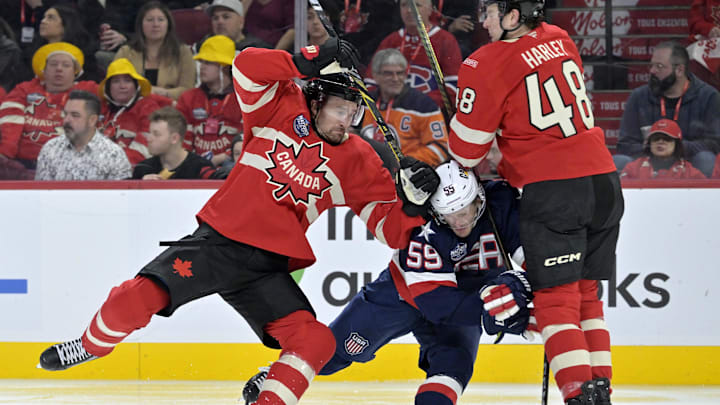 Feb 15, 2025; Montreal, Quebec, CAN; [Imagn Images direct customers only] Team Canada forward Mark Stone (61) and teammate Team Canada defenseman Thomas Harley (48) check Team United States forward Jake Guentzel (59) in the third period during a 4 Nations Face-Off ice hockey game at the Bell Centre. Mandatory Credit: Eric Bolte-Imagn Images