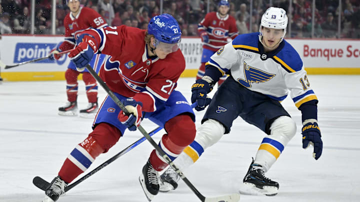 Feb 11, 2024; Montreal, Quebec, CAN; Montreal Canadiens defenseman Kaiden Guhle (21) plays the puck and St.Louis Blues forward Alexey Toropchenko (13) forechecks during the first period at the Bell Centre. Mandatory Credit: Eric Bolte-Imagn Images