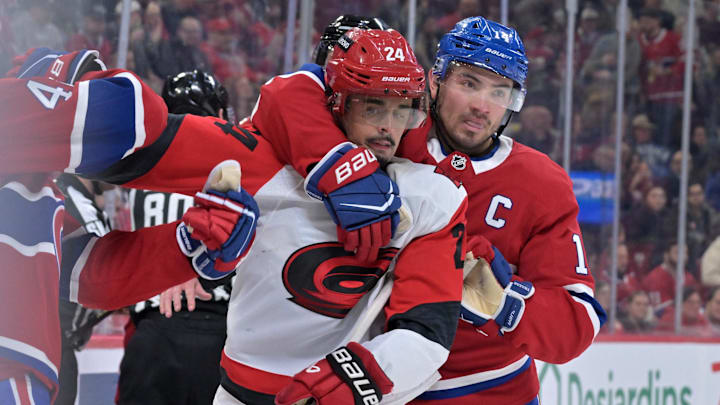 Mar 24, 2026; Montreal, Quebec, CAN; Montreal Canadiens forward Nick Suzuki (14) stops Carolina Hurricanes forward Seth Jarvis (24) from grabbing Montreal Canadiens defenseman Lane Hutson (48) during the second period at the Bell Centre. Mandatory Credit: Eric Bolte-Imagn Images