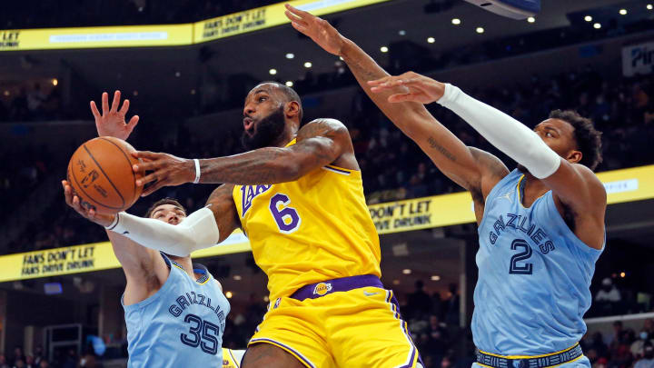 Dec 9, 2021; Memphis, Tennessee, USA; Los Angeles Lakers forward LeBron James (6) drives to the basket as Memphis Grizzles forward Killian Tillie (35) and Memphis Grizzles forward Xavier Tillman Sr. (2) defend during the first half at FedExForum. 