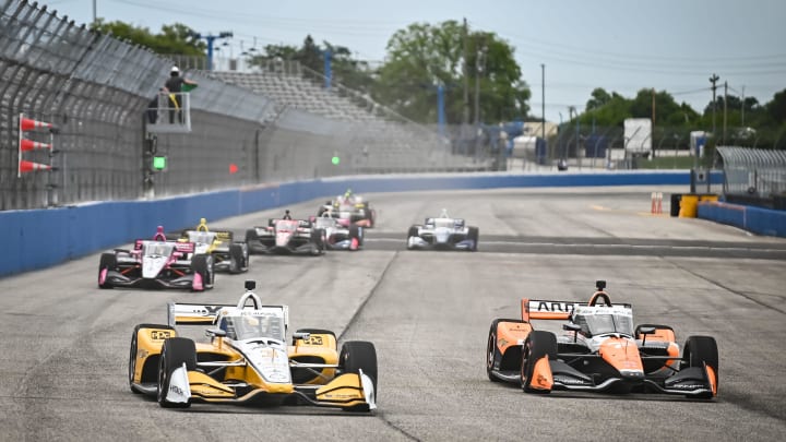 Team Penske driver Scott McLaughlin (3) and Arrow McLaren driver Alexander Rossi (7) leads a pack of cars into Turn 1 during the NTT IndyCar Series hybrid test Tuesday, June 11, 2024, at the Milwaukee Mile in West Allis, Wisconsin.