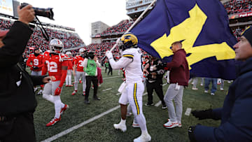 Nov 30, 2024; Columbus, Ohio, USA;  Michigan Wolverines defensive end Derrick Moore (8) attempts to plant the flag on the Ohio State Buckeyes logo as Ohio State Buckeyes defensive end Jack Sawyer (33) rips the flag down after the game at Ohio Stadium. Mandatory Credit: Joseph Maiorana-Imagn Images