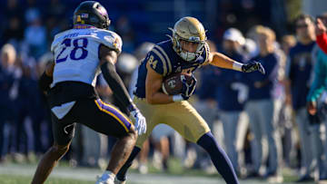 Nov 18, 2023; Annapolis, Maryland, USA; Navy Midshipmen wide receiver Regis Velez (84) runs the ball against East Carolina Pirates defensive back Shavon Revel (28) during the second quarter at Navy-Marine Corps Memorial Stadium. Mandatory Credit: Reggie Hildred-Imagn Images