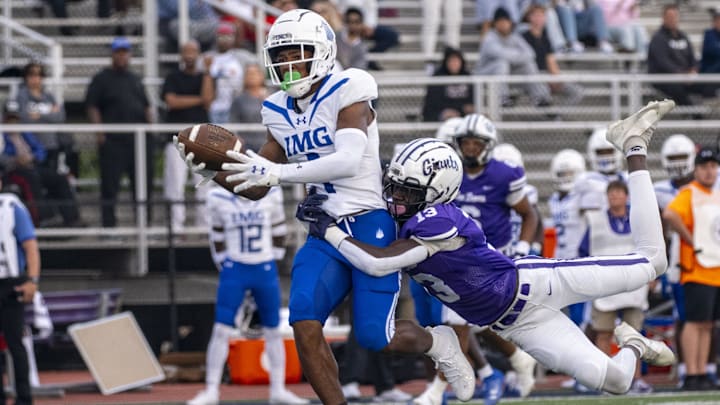 IMG Academy High School junior Donovan Olugbode (1) makes a catch while being defended by Ben Davis High School senior Yassine Falke (13) during the first half of an IHSAA varsity football game, Friday, Sept. 8, 2023, at Ben Davis High School.