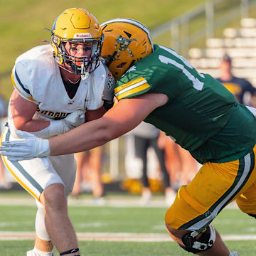 Howells' Bobby Kanka (right) hauls down Hudsonville's Quinn Poll Thursday, Aug. 29, 2024.