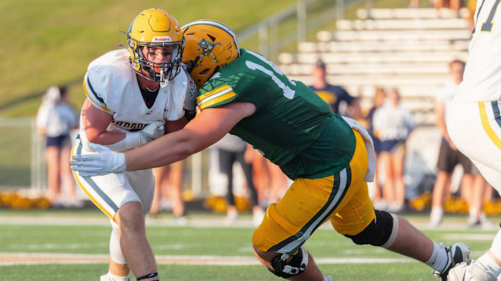 Howells' Bobby Kanka (right) hauls down Hudsonville's Quinn Poll Thursday, Aug. 29, 2024.