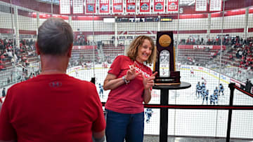 Kathy Butts Richardson of Madison poses with the 2025 NCAA women’s hockey national championship trophy won by Wisconsin before the game between Wisconsin and Maine on Friday, October 3, 2025, at LaBahn Arena in Madison, Wisconsin.