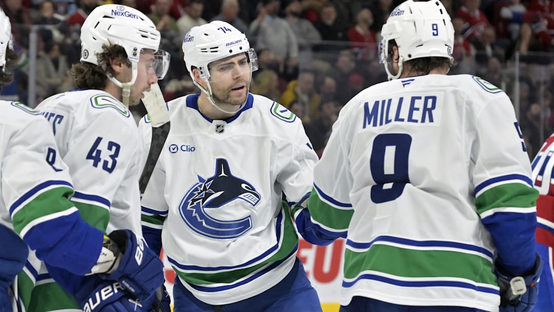 Jan 6, 2025; Montreal, Quebec, CAN; Vancouver Canucks forward Jake Debrusk (74) celebrates with teammates including forward J.T. Miller (9) after scoring a goal against the Montreal Canadiens during the third period at the Bell Centre. Mandatory Credit: Eric Bolte-Imagn Images