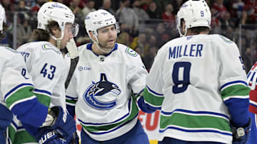 Jan 6, 2025; Montreal, Quebec, CAN; Vancouver Canucks forward Jake Debrusk (74) celebrates with teammates including forward J.T. Miller (9) after scoring a goal against the Montreal Canadiens during the third period at the Bell Centre. Mandatory Credit: Eric Bolte-Imagn Images